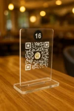 Restoran masasında duran şeffaf pleksi QR kodlu menü numarası – dijital temassız menü çözümü